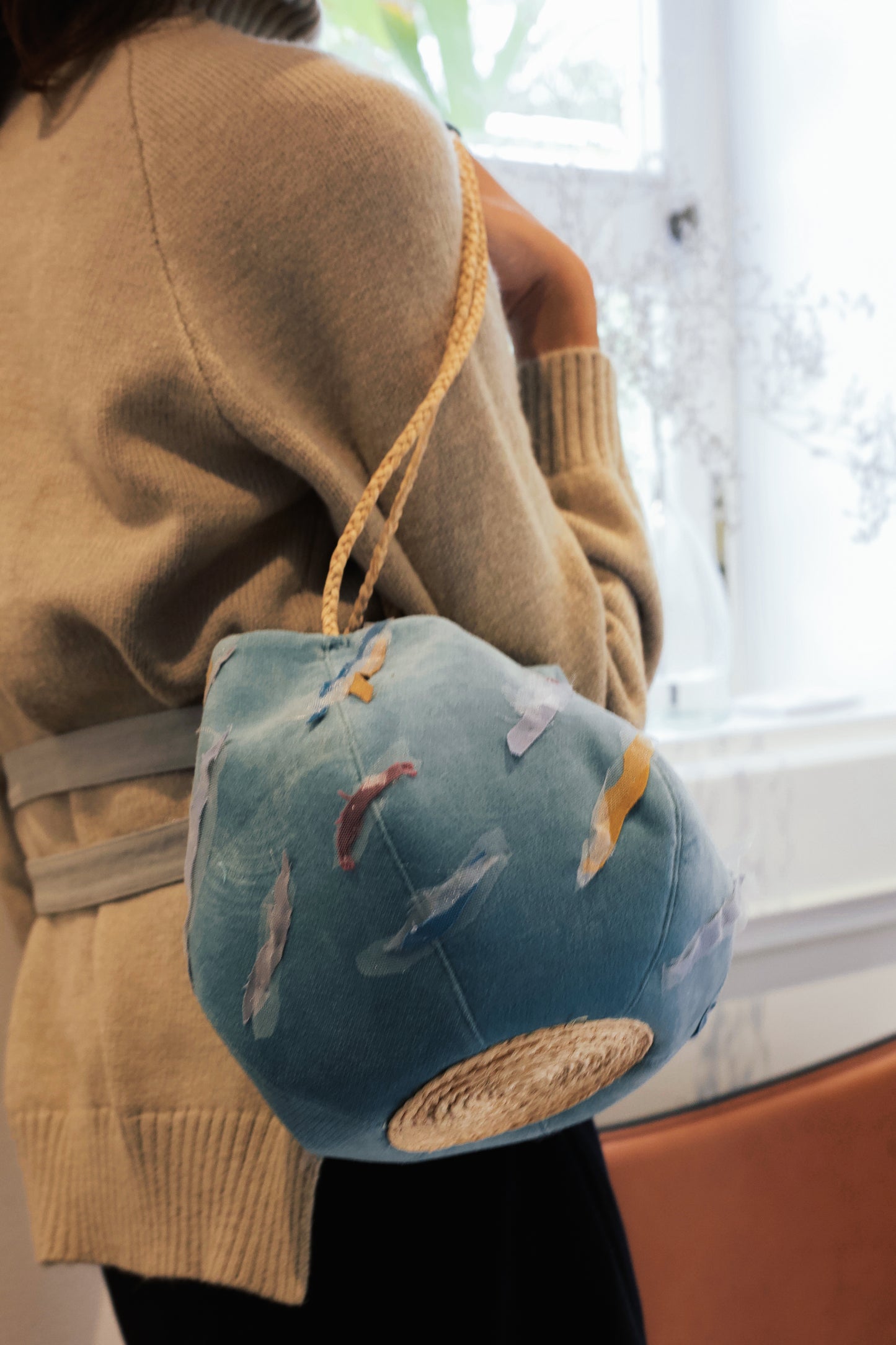 Sunset Boulevard bag made from natural and repurposed materials and featuring a one-of-a-kind hand ornamental applique on the bag's body. Wear it on your shoulders or hold it in your hands with the adjustable strap for a charming nighttime look.